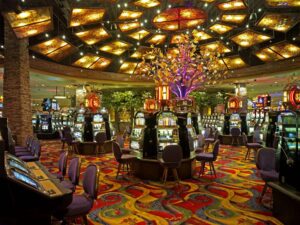 A casino with slot machines and a chandelier located at Black Oak Casino & Hotel.