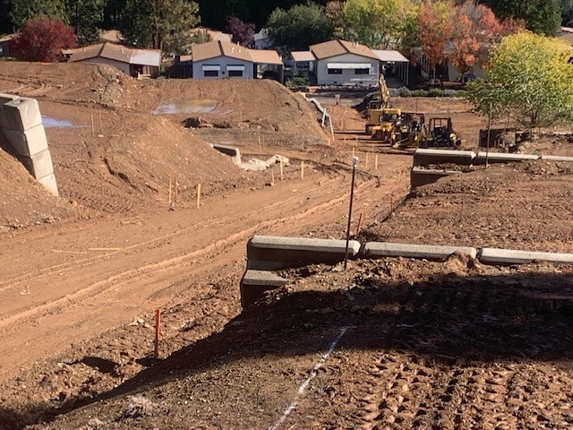 A construction site with a dirt road in the background.