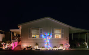 A mobile home is decorated with Christmas lights at Mill Villa Estates.