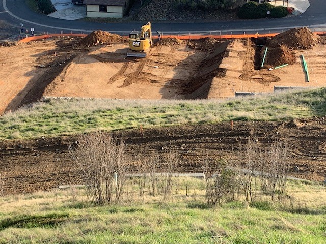 A construction crew is working on a hillside.