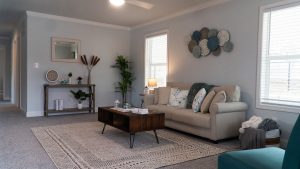 A living room with a couch and a coffee table is featured in the grand opening.