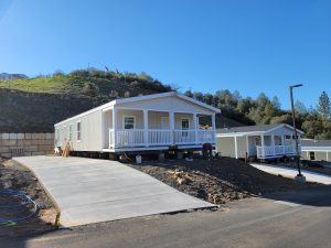 Open house showcasing two mobile homes on a hillside.