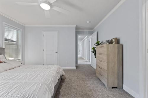 A bedroom with gray walls and a ceiling fan.