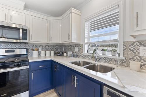 A blue and white kitchen with stainless steel appliances.