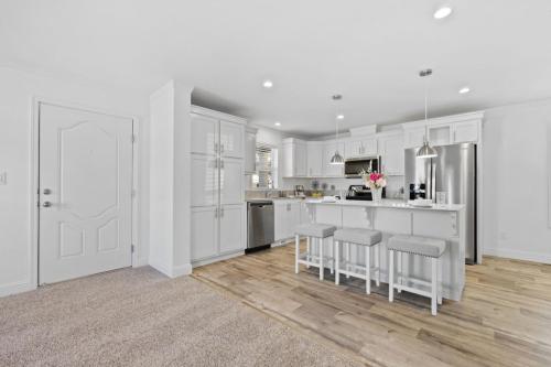 A kitchen with white cabinets and hardwood floors.