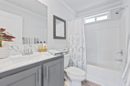 A bathroom with gray cabinets and a white toilet.