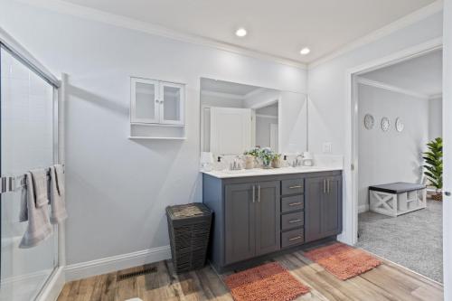 A bathroom with wood floors and gray walls.