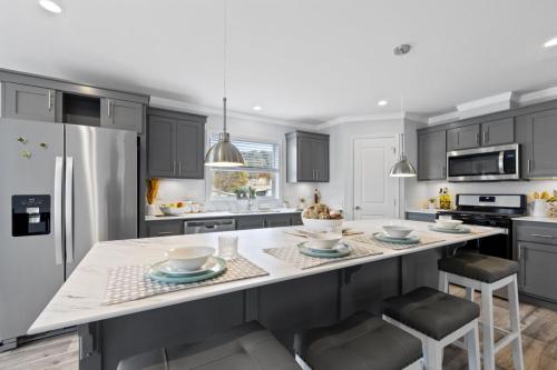 A kitchen with gray cabinets and a center island.