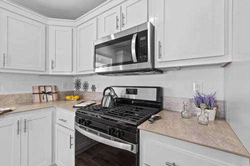 A kitchen with white cabinets and a microwave oven.