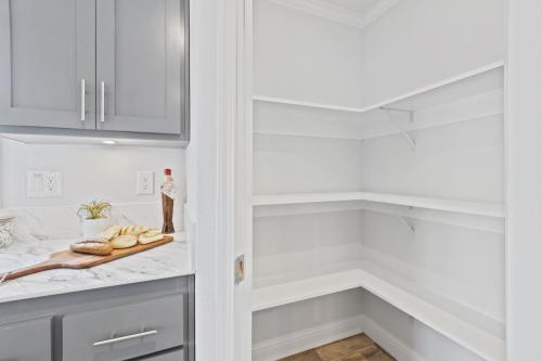 A kitchen with white cabinets and a pantry.